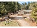 Well-maintained home with a two-car garage, complemented by a storage shed and wooded surroundings at 993 Fall River Rd, Idaho Springs, CO 80452