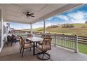 Inviting covered patio with a dining table, chairs, and scenic views of the surrounding landscape at 3898 Descent St, Castle Rock, CO 80108