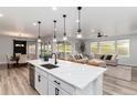 Open-concept kitchen features a large island, modern appliances, and seamless flow into the adjacent living and dining areas at 3898 Descent St, Castle Rock, CO 80108