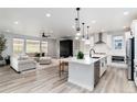 Bright, open living area with hardwood floors, recessed lighting, and a kitchen with stainless steel appliances at 3898 Descent St, Castle Rock, CO 80108