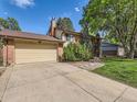 This house has a big driveway and a two car garage with a well manicured lawn at 6160 Taft Ct, Arvada, CO 80004