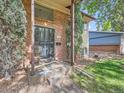 Inviting covered front entrance with security door and landscaped front yard featuring mature trees at 6160 Taft Ct, Arvada, CO 80004