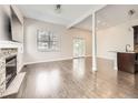 Bright, open living room featuring hardwood floors, fireplace, large windows, and seamless transition to the kitchen at 2216 S Nile Ct, Aurora, CO 80014