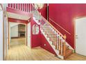 Inviting foyer with hardwood floors, a staircase, and a glimpse into the living area with a fireplace at 12258 E Lasalle Pl, Aurora, CO 80014