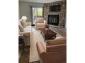 Comfortable living room featuring a stone fireplace and neutral-toned furniture at 10810 Summerset Way, Parker, CO 80138