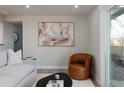 Cozy living room featuring a statement chair, modern art, and natural light from the nearby door at 1020 Stuart, Denver, CO 80204