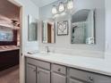 Bright bathroom with a gray vanity, dual mirrors, and a shower with a glass door at 4063 S Cathay Ct, Aurora, CO 80013