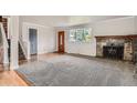 Bright living room with hardwood floors, a fireplace, and large windows that let in natural light at 6864 Balsam St, Arvada, CO 80004