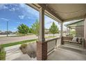 Relaxing front porch with a swing, brick pillars, and a view of the neighborhood at 11270 E 26Th Ave, Aurora, CO 80010