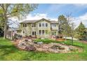 A serene backyard featuring a tranquil water feature, a patio, and mature trees at 25 Summit Ash, Littleton, CO 80127