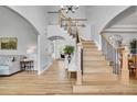 Elegant foyer with hardwood floors, a staircase with black iron railings, and a view into the living room at 25 Summit Ash, Littleton, CO 80127