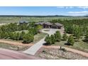 Expansive property showcases a well-maintained house with a long driveway and circular turnaround at 1505 Castlecombe Ln, Monument, CO 80132