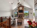 Bright living room with vaulted ceilings, a stone fireplace, large windows with scenic views, and hardwood floors at 1505 Castlecombe Ln, Monument, CO 80132