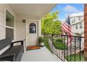 Charming covered balcony includes an American flag, bench seating, potted plant and a view of green space at 1670 S Deframe St # B2, Lakewood, CO 80228
