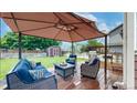 Backyard featuring a large canopy-covered seating area, wooden deck, and lush green grass at 12201 N Holly Way, Brighton, CO 80602