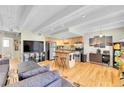 Open living room featuring a modern kitchen with stainless appliances and hardwood floors at 33 Corona St # 207, Denver, CO 80218