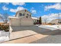 Two-story house with a three-car garage and snow-covered landscaping at 10890 W Belmont Ave, Littleton, CO 80127