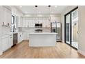 Bright kitchen featuring white cabinets, stainless appliances, and a kitchen island at 1563 N Hooker St, Denver, CO 80204