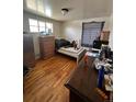 Small bedroom with hardwood floors and a window, featuring a simple bed and functional furniture at 1255 Yates St, Denver, CO 80204