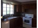 Functional kitchen featuring wood cabinets, an electric range, and essential appliances, bathed in natural light at 1255 Yates St, Denver, CO 80204