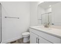 Clean bathroom with glass-enclosed shower, modern fixtures, and white vanity at 8630 Pennycress Dr, Littleton, CO 80125