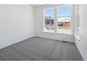 Bright bedroom with neutral carpet and two large windows overlooking the neighborhood at 8630 Pennycress Dr, Littleton, CO 80125