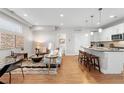 Bright open-concept living room flows into kitchen with counter seating and modern white cabinets at 1245 N Utica St # 103, Denver, CO 80204