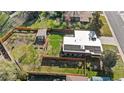 Aerial view of a property with a large, fenced backyard, mature trees, and solar panels at 3035 E Maplewood Ave, Centennial, CO 80121