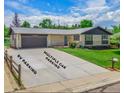 Exterior shot highlighting the long driveway with ample parking, attached garage, and well-kept front yard at 13010 W 6Th Pl, Golden, CO 80401
