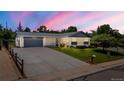 Exterior featuring a spacious driveway leading to an attached garage, complemented by a neatly landscaped yard at 13010 W 6Th Pl, Golden, CO 80401
