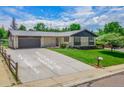 Charming single-story home with a well-manicured lawn, a long driveway, and an attached garage at 13010 W 6Th Pl, Golden, CO 80401