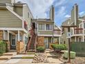 Condo with brick facade, stairs with red railings, well maintained landscaping, and walkway to the unit at 962 S Dearborn Way # 19, Aurora, CO 80012
