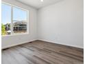 Bright bedroom featuring large windows and stylish, neutral-toned hardwood flooring at 8241 Rockvale Dr, Littleton, CO 80125