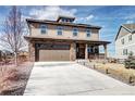 Charming two-story home featuring a concrete driveway, stone accents, and a two-car garage at 7353 S Queensburg St, Aurora, CO 80016