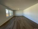 Open-concept living room boasts hardwood floors and large windows, bringing in plenty of sunlight at 22057 E 39Th Pl, Aurora, CO 80019