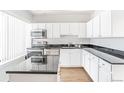 Modern kitchen with white cabinets and granite countertops at 70 W 6Th Ave # 109, Denver, CO 80204