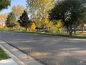 A peaceful street view with mature trees and wooden fencing, offering a glimpse of the neighborhood's charm at 995 W Peakview Cir, Littleton, CO 80120