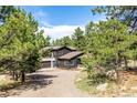A large home sits back on a graveled driveway surrounded by trees at 37 Wagner Cir, Boulder, CO 80304