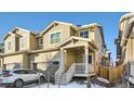 Tan two-story townhome with attached garage and front porch at 677 Brookwood Dr, Lafayette, CO 80026