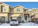 Tan two-story townhome with attached garage and front porch at 677 Brookwood Dr, Lafayette, CO 80026