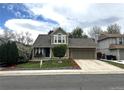 Charming two-story home with manicured lawn, mature trees, and a welcoming front porch at 13474 W 65Th Dr, Arvada, CO 80004