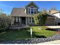 Charming two-story home with landscaped yard, front patio, and inviting curb appeal at 13474 W 65Th Dr, Arvada, CO 80004