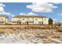 Tan townhouses with wooden fences and snowy ground in the front at 16058 E Geddes Ln # 26, Aurora, CO 80016