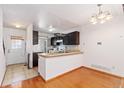 Inviting dining area adjacent to the kitchen with dark cabinets and hardwood floors at 9844 Fairwood St, Littleton, CO 80125