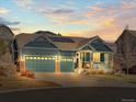 Charming two-story home with a three-car garage and solar panels on the roof during sunset at 23327 E Ottawa Dr, Aurora, CO 80016