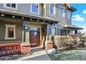 Inviting covered porch with brick columns and stylish lighting welcomes you to the home at 10112 Bluffmont Ln, Lone Tree, CO 80124