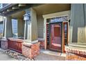 Close-up of the front porch featuring brick accents, stylish lighting, and the front door at 10112 Bluffmont Ln, Lone Tree, CO 80124