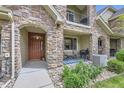 Charming front porch with stone pillars, seating area, and a welcoming front door at 15362 W 66Th Ave # D, Arvada, CO 80007