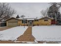 Classic home featuring a brick facade and a snow-covered yard at 306 S Newport Way, Denver, CO 80224