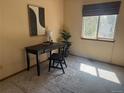 Minimalist bedroom with a dark desk, chair, accent rug, and natural light from the window at 2136 S Scranton Way, Aurora, CO 80014